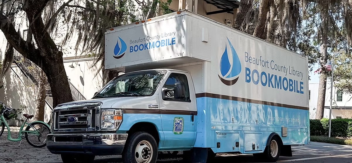 The Beaufort County Library Bookmobile sits parked under oak trees.