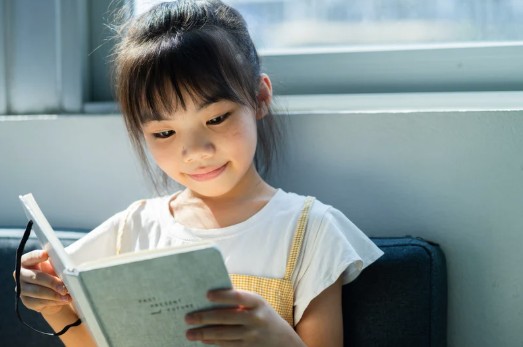 Smiling girl reading a book